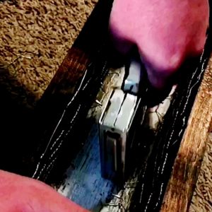 Man using staple gun to staple chicken wire onto wood planter